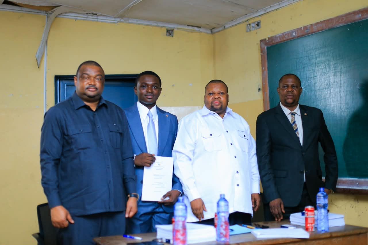 Michel Nonga, mémoire en main, entouré des membres du jury à l'Université de Kinshasa